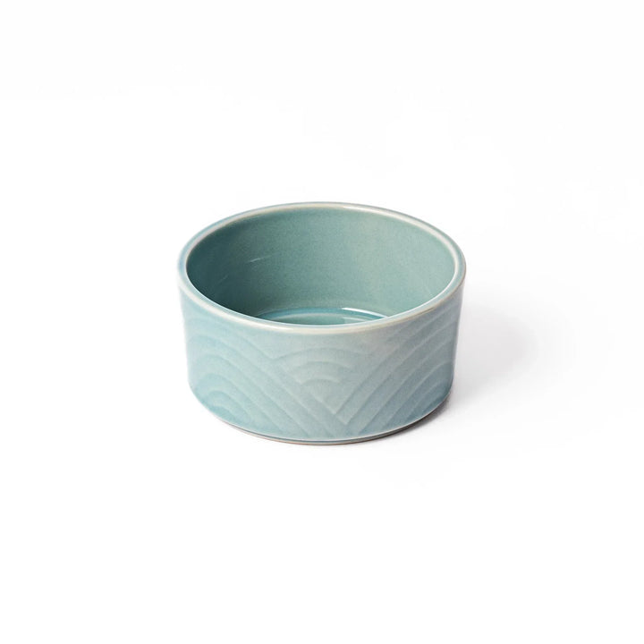 Light blue stackable Japanese porcelain bowl with embossed Seigaiha wave pattern and smooth matte texture.