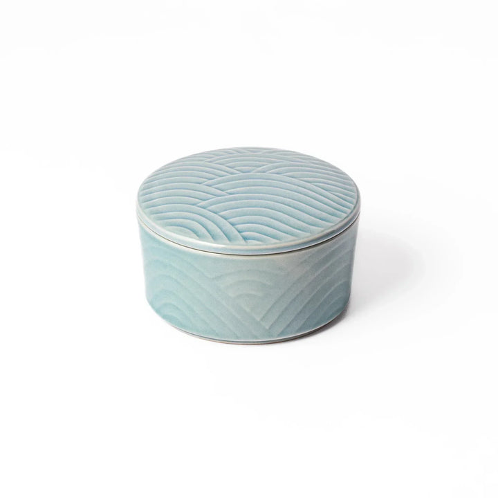 Light blue stackable Japanese porcelain bowl with embossed Seigaiha wave pattern and smooth matte texture.