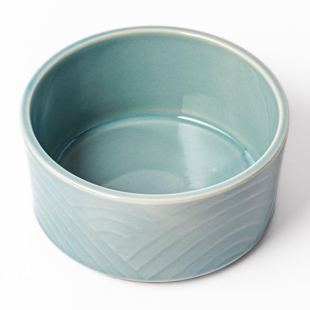 Light blue stackable Japanese porcelain bowl with embossed Seigaiha wave pattern and smooth matte texture.