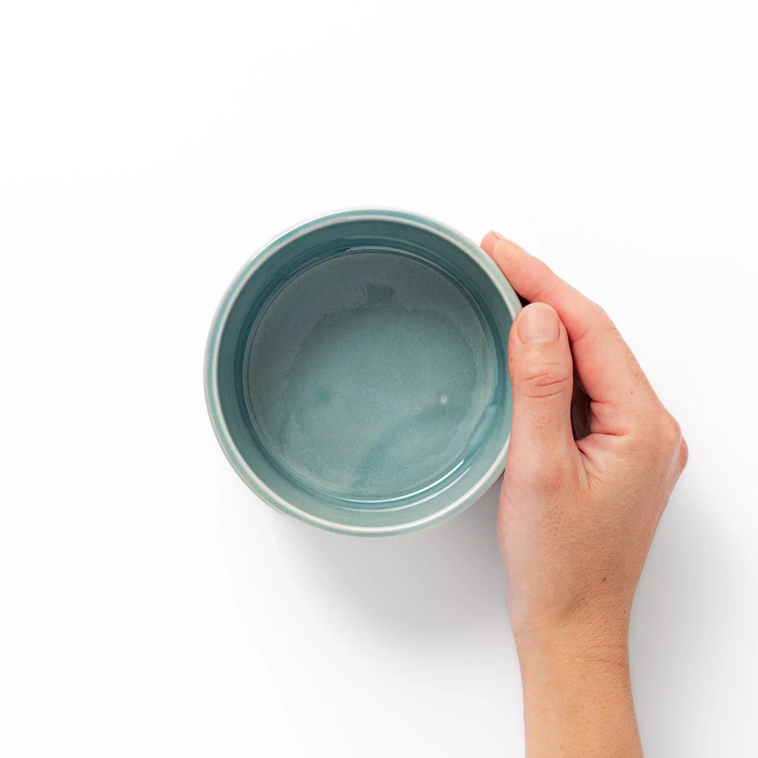 Light blue stackable Japanese porcelain bowl with embossed Seigaiha wave pattern and smooth matte texture.