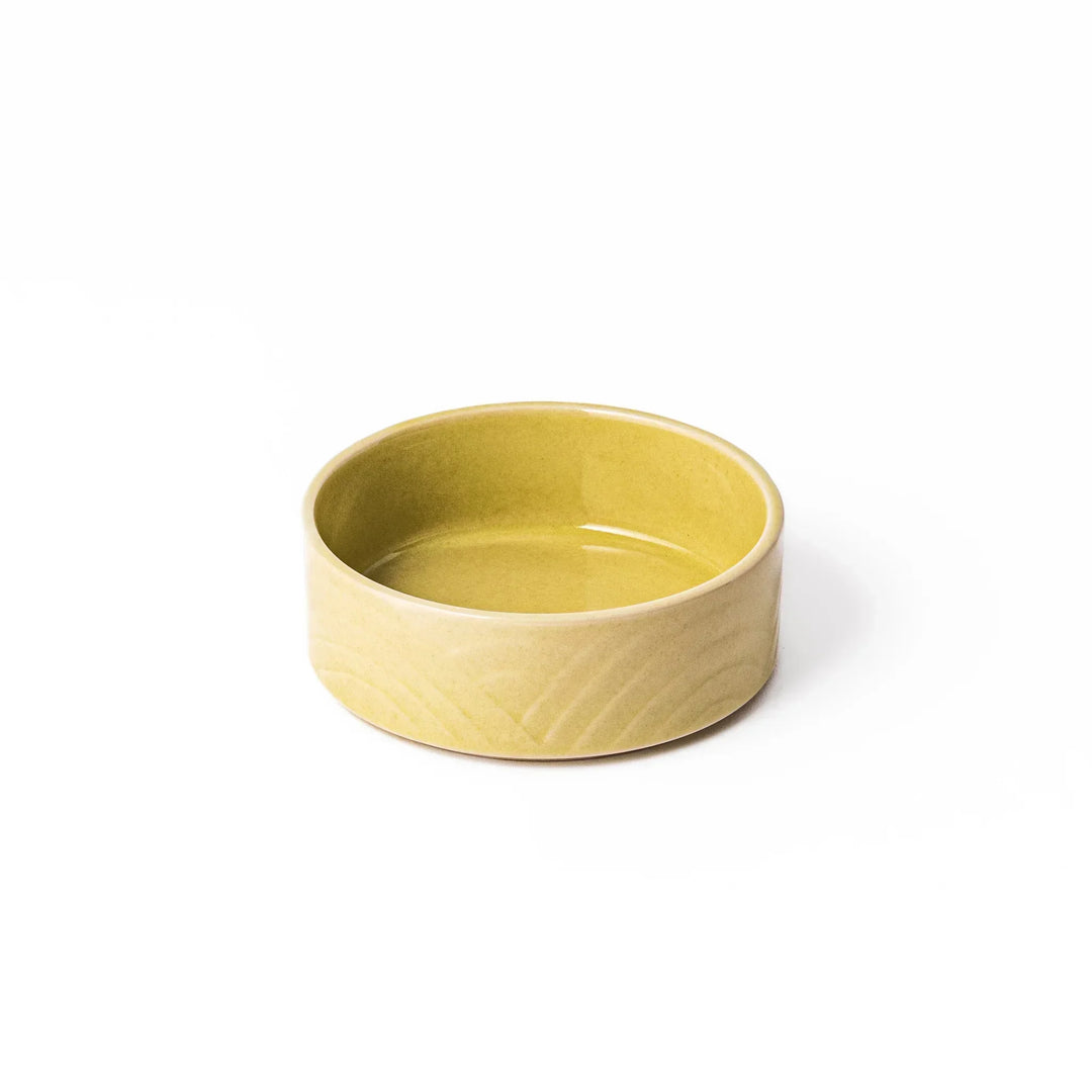 Small yellow Japanese porcelain bowl with embossed Seigaiha wave pattern matte finish and minimalist design.