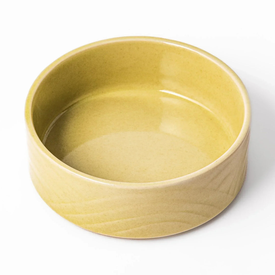Small yellow Japanese porcelain bowl with embossed Seigaiha wave pattern matte finish and minimalist design.