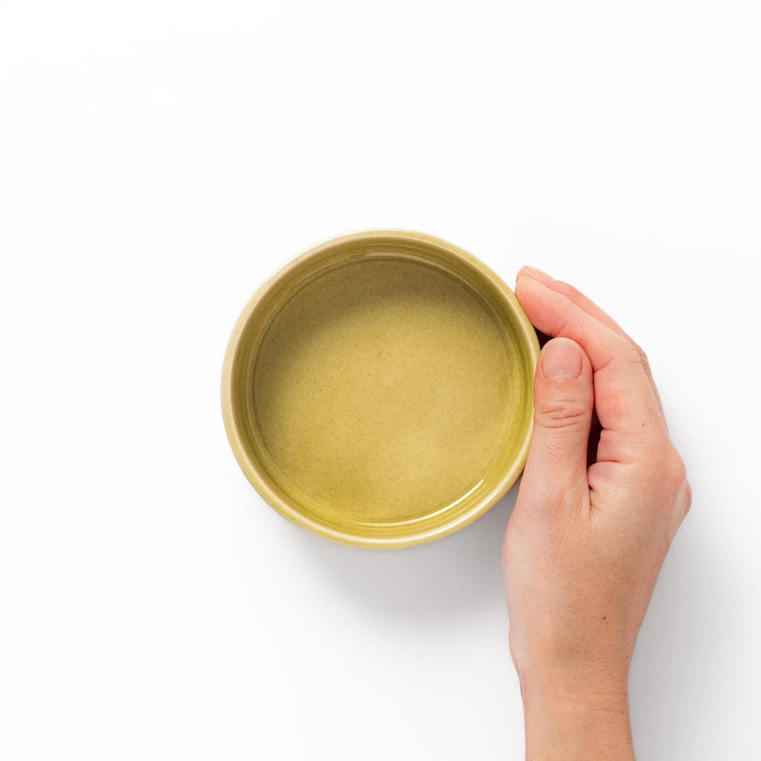Small yellow Japanese porcelain bowl with embossed Seigaiha wave pattern matte finish and minimalist design.