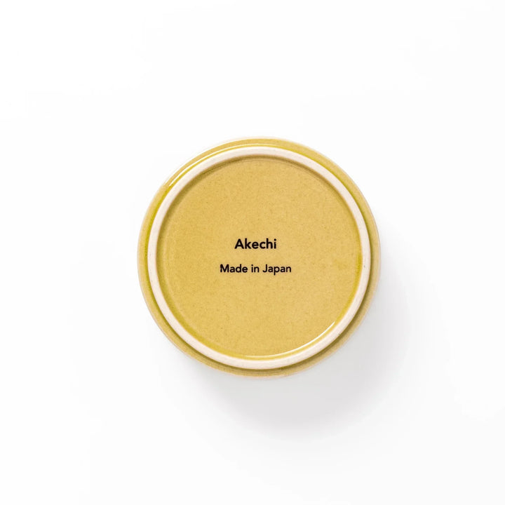 Small yellow Japanese porcelain bowl with embossed Seigaiha wave pattern matte finish and minimalist design.