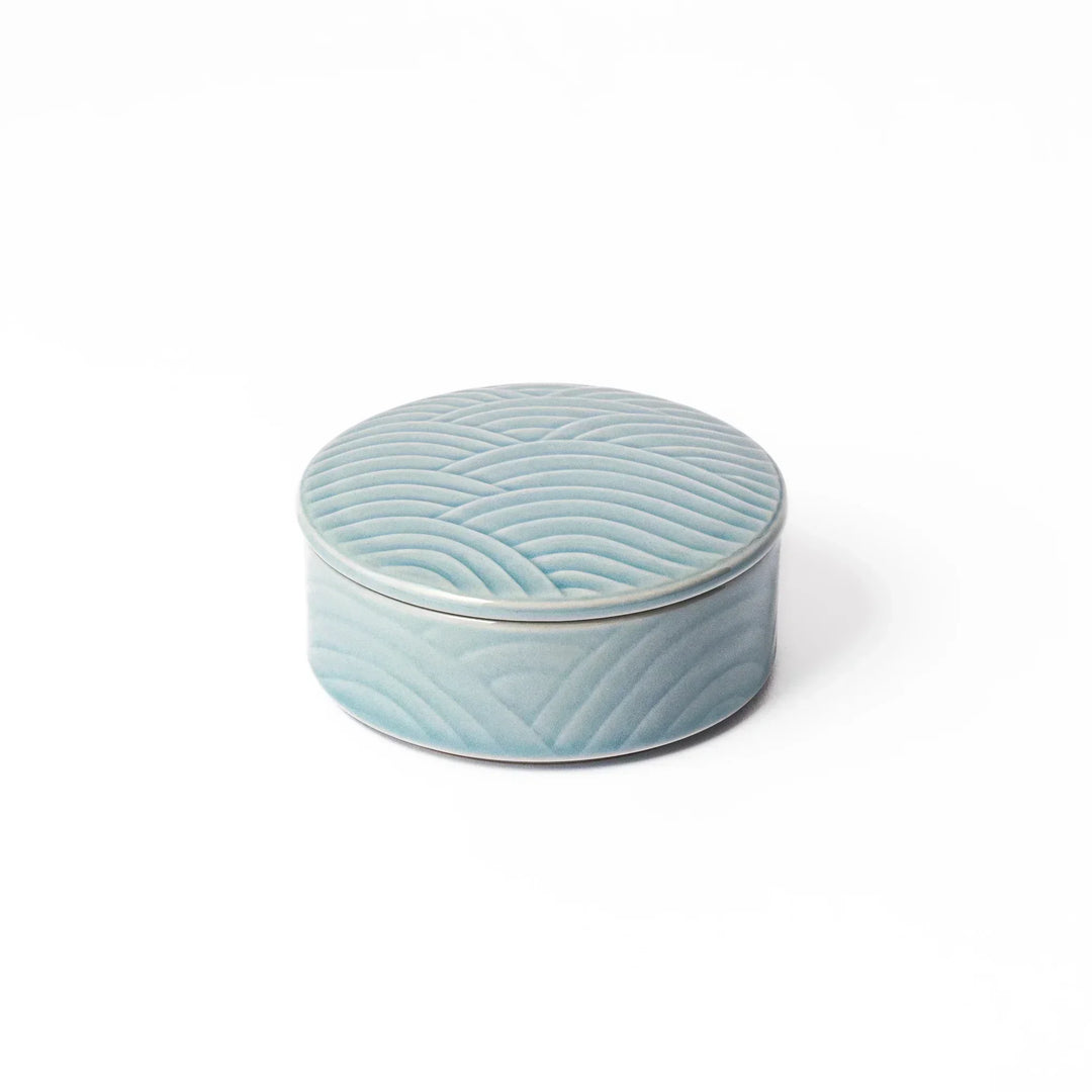 Light blue stackable Japanese porcelain bowl with embossed Seigaiha wave pattern and smooth matte texture.