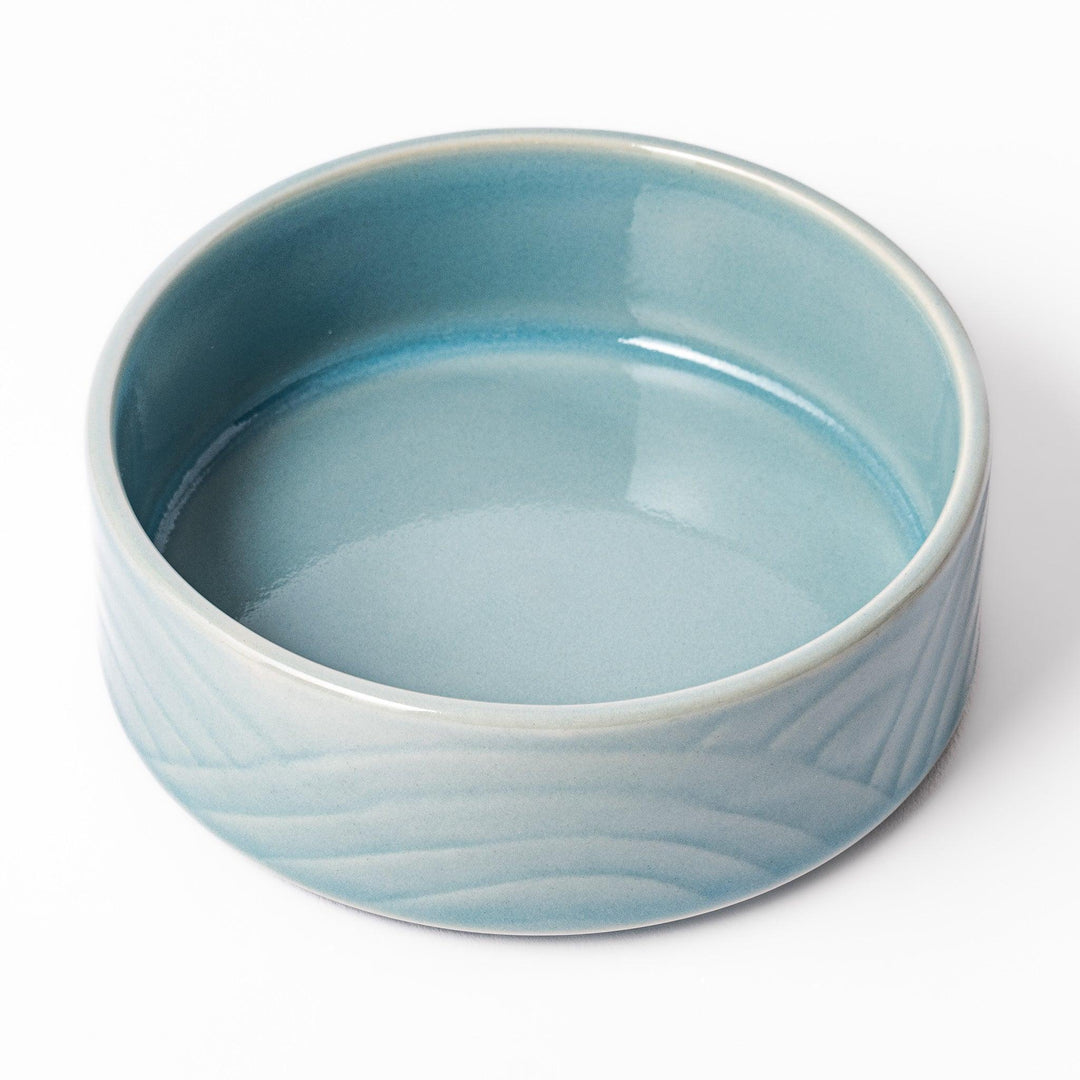 Light blue porcelain bowl embossed with a gentle Seigaiha wave pattern, showcasing a serene and minimalist Japanese design.