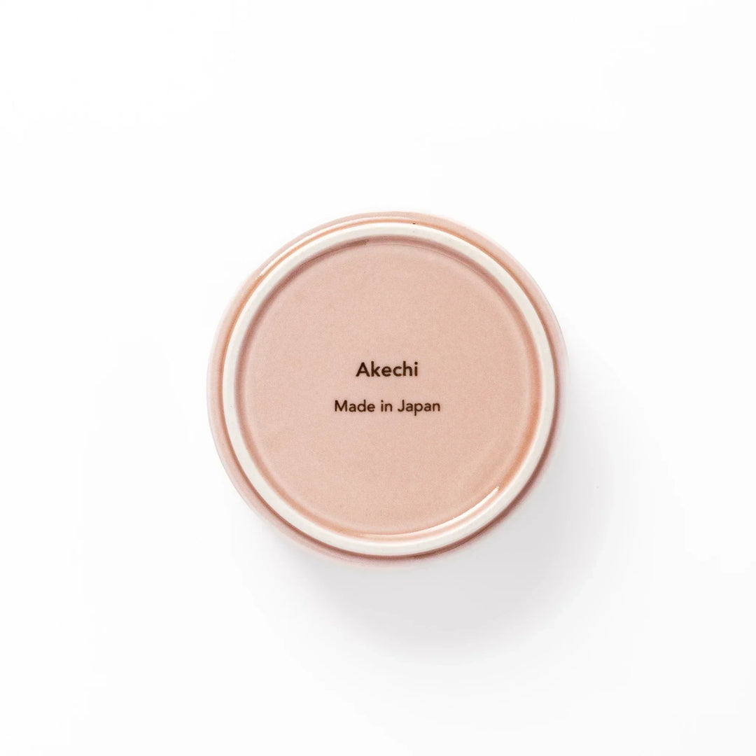 Light pink Japanese porcelain bowl with embossed wave pattern glossy finish and simple cylindrical shape.