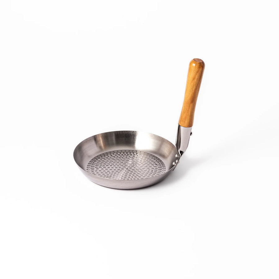 Japanese stainless steel donburi pot with wooden handle and hammered base for heating rice bowls and sauces.