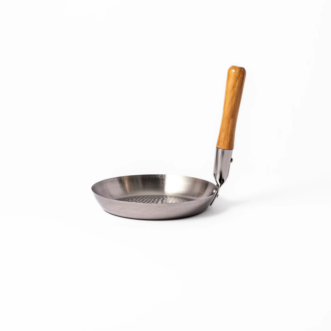 Japanese stainless steel donburi pot with wooden handle and hammered base for heating rice bowls and sauces.