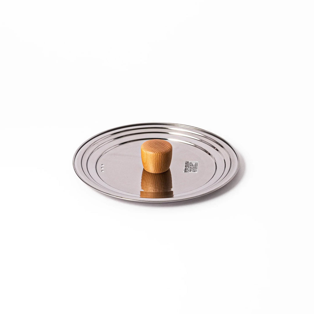 Stainless steel lid with wooden knob for Yukihira pots blending modern simplicity and Japanese craftsmanship.