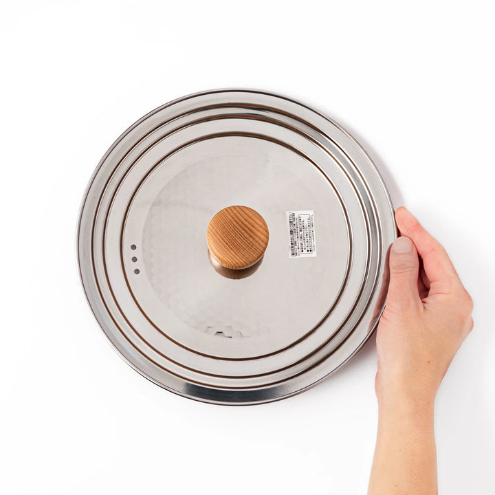Stainless steel lid with wooden knob for Yukihira pots blending modern simplicity and Japanese craftsmanship.