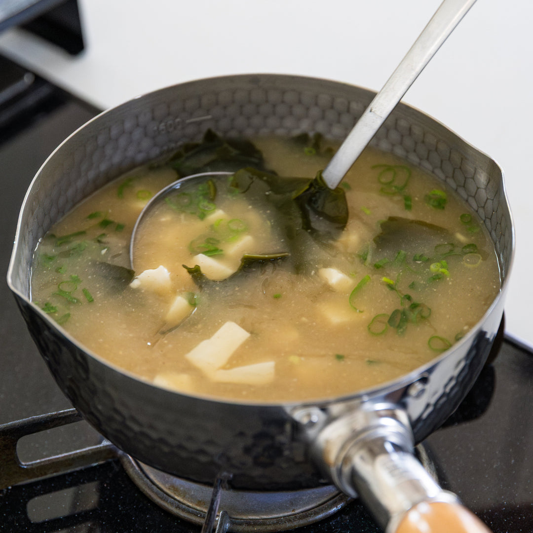 Stainless Steel Yukihira Pot cooking miso soup with tofu wakame and green onion