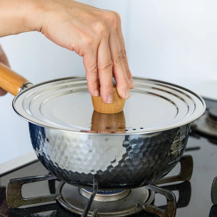 Stainless Steel Yukihira Pot with lid and wooden knob simmering on gas stove