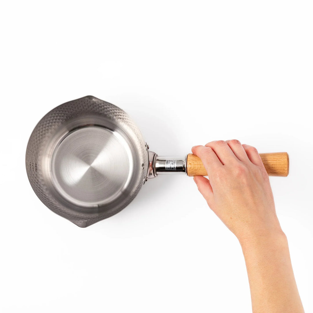 Japanese stainless steel yukihira pot with wooden handle and hammered texture, ideal for boiling soup or simmering dishes