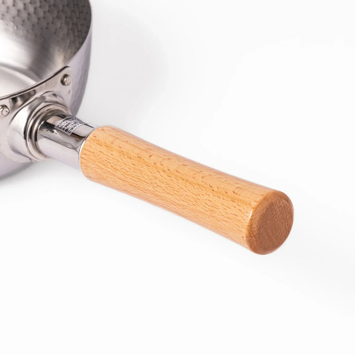 Japanese stainless steel yukihira pot with wooden handle and hammered texture, ideal for boiling soup or simmering dishes