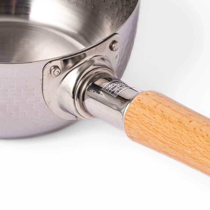 Japanese stainless steel yukihira pot with wooden handle and hammered texture, ideal for boiling soup or simmering dishes