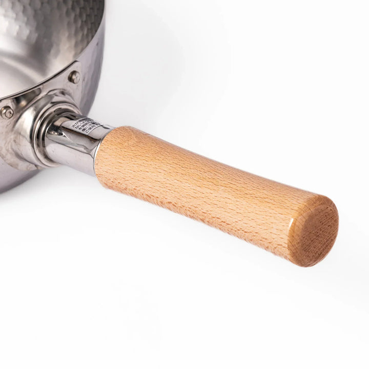 Stainless steel Yukihira pot with a wooden handle featuring a hammered texture and dual pour spouts.