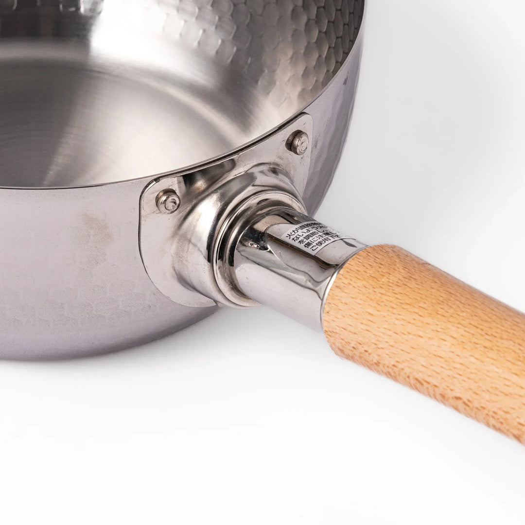 Stainless steel Yukihira pot with a wooden handle featuring a hammered texture and dual pour spouts.