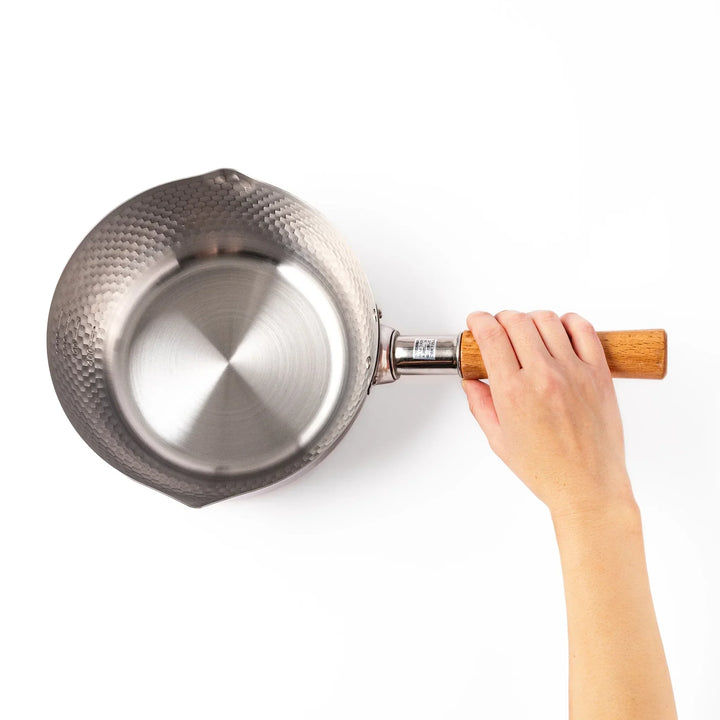 Japanese stainless steel yukihira pot with wooden handle and hammered texture, ideal for boiling soup or simmering dishes