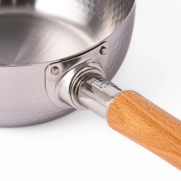Japanese stainless steel yukihira pot with wooden handle and hammered texture, ideal for boiling soup or simmering dishes