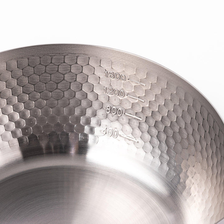 Japanese stainless steel yukihira pot with wooden handle and hammered texture, ideal for boiling soup or simmering dishes