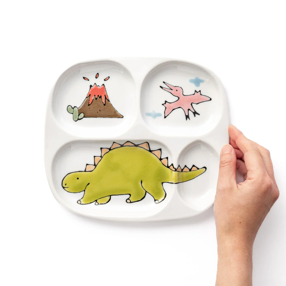 White ceramic kids divided plate with green stegosaurus, red erupting volcano, pink pterodactyl and blue cloud motifs