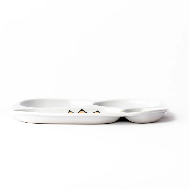 White ceramic kids divided plate with green stegosaurus, red erupting volcano, pink pterodactyl and blue cloud motifs