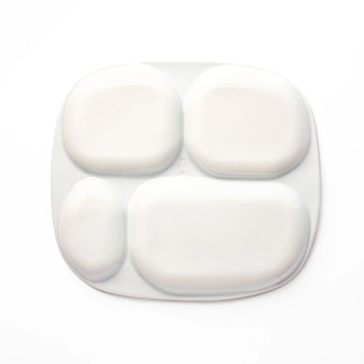 White ceramic kids divided plate with green stegosaurus, red erupting volcano, pink pterodactyl and blue cloud motifs