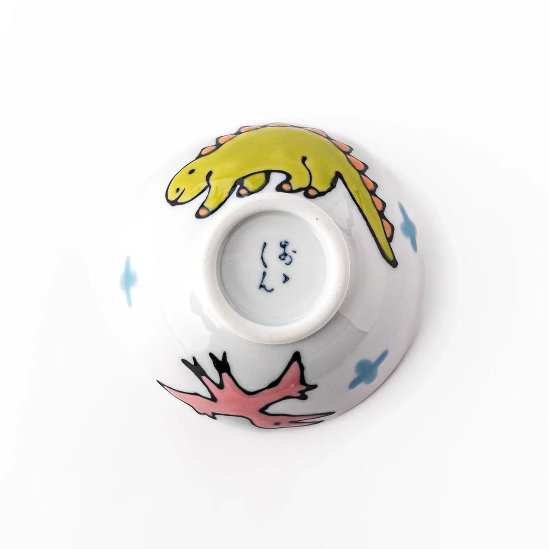 White ceramic kids rice bowl with green stegosaurus dinosaur motif and blue cloud accents