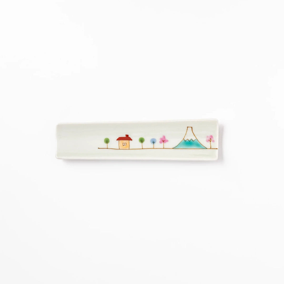 Japanese porcelain chopstick rest with whimsical Japan motif of Mount Fuji, cherry blossoms, and colorful trees.