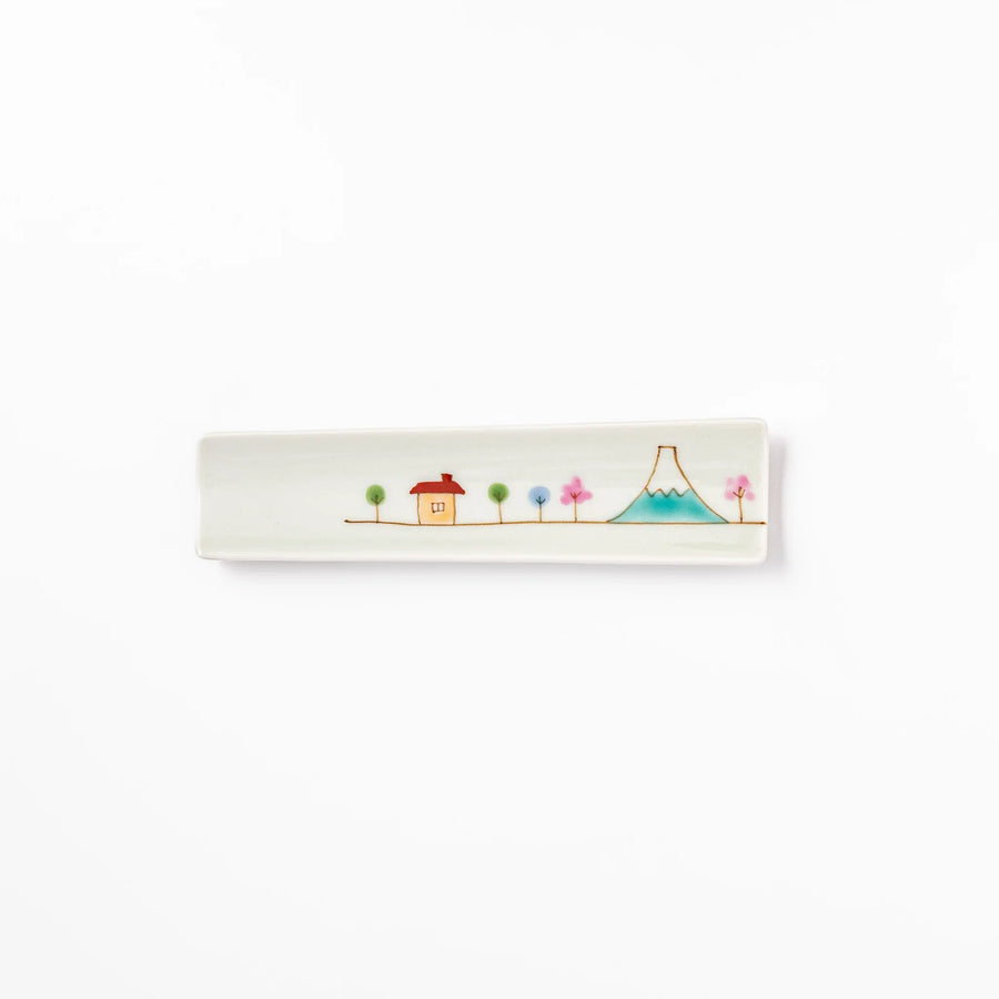 Japanese porcelain chopstick rest with whimsical Japan motif of Mount Fuji, cherry blossoms, and colorful trees.