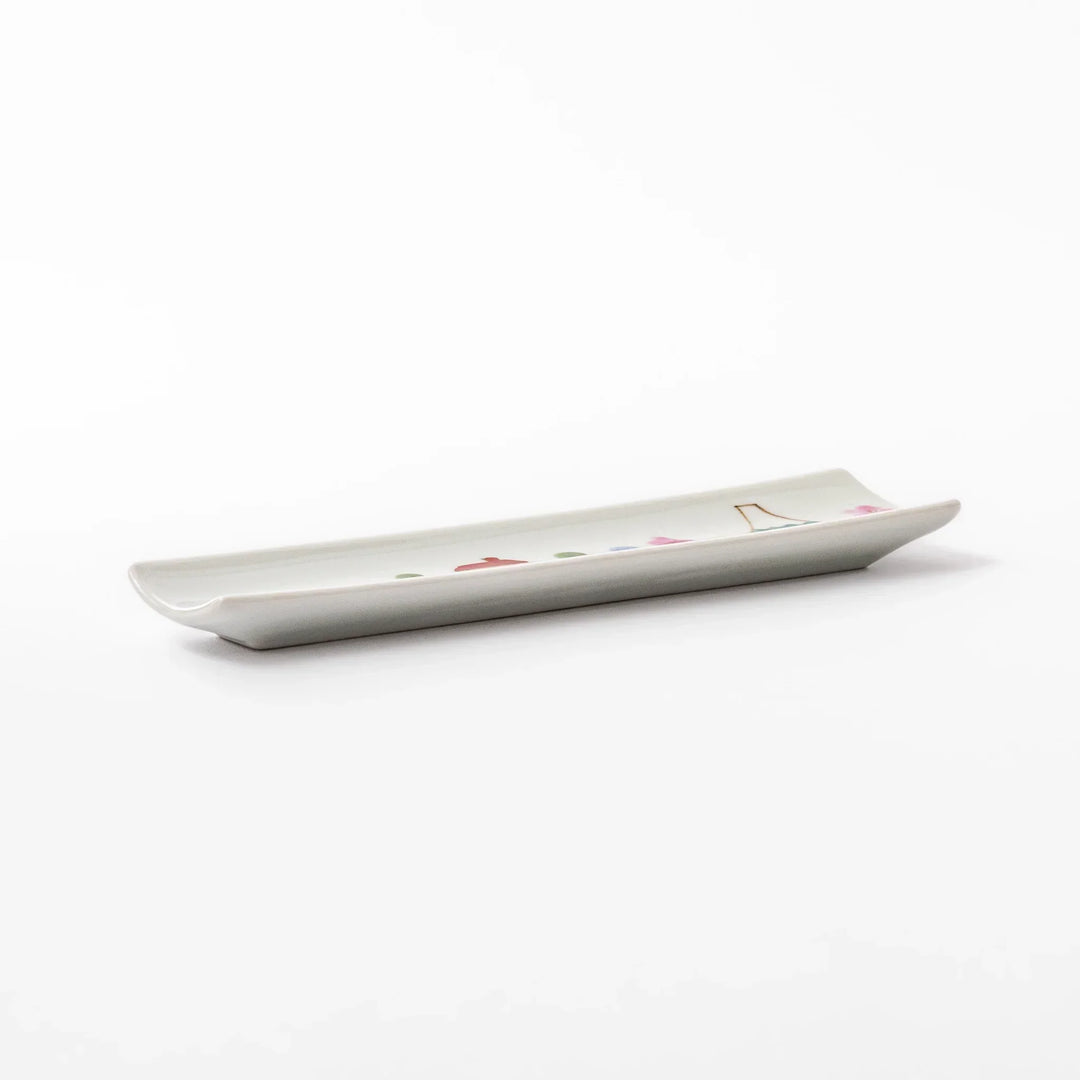 Japanese porcelain chopstick rest with whimsical Japan design featuring Mount Fuji, cherry blossoms, house, and colorful trees