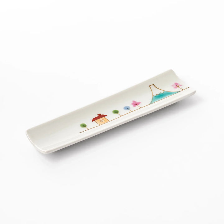 Japanese porcelain chopstick rest with whimsical Japan design featuring Mount Fuji, cherry blossoms, house, and colorful trees