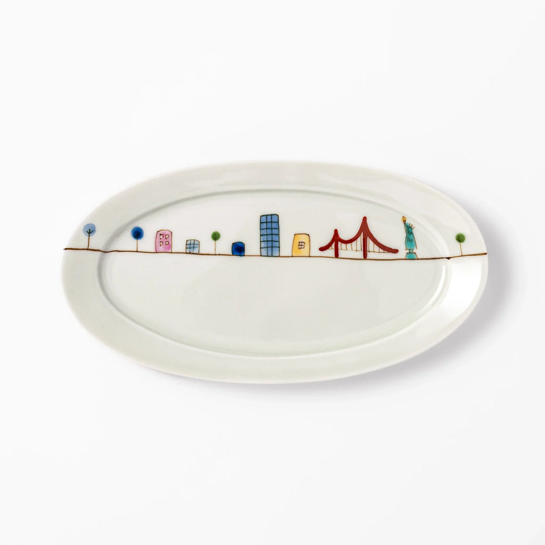 Japanese porcelain oval plate with playful USA cityscape design featuring Statue of Liberty, bridge, and colorful buildings