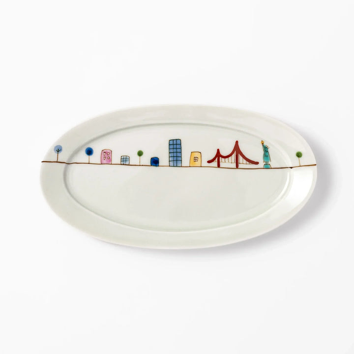 Japanese porcelain oval plate with playful USA cityscape design featuring Statue of Liberty, bridge, and colorful buildings
