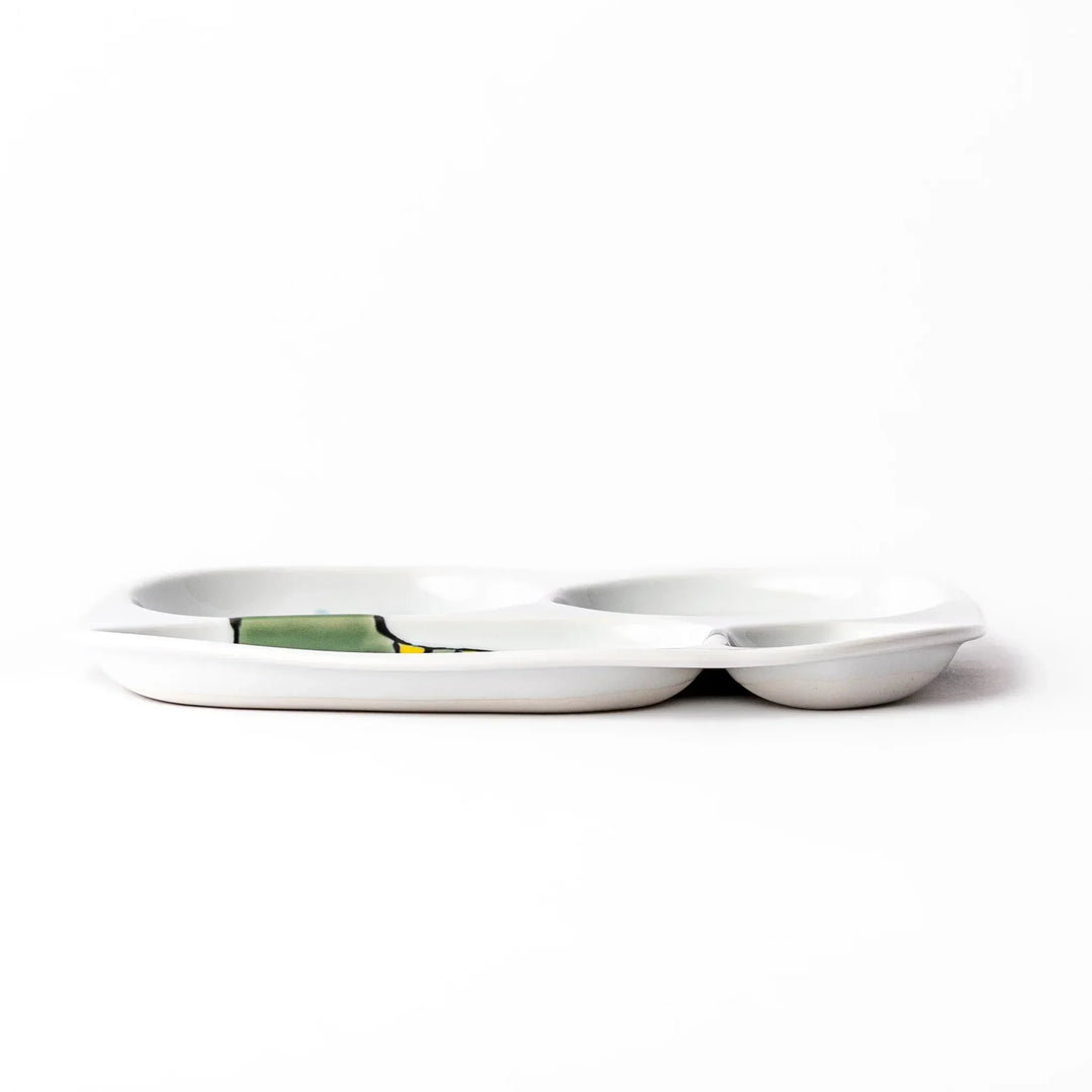 White ceramic kids divided plate with green T-Rex, purple pterodactyl, yellow grass and blue cloud accents