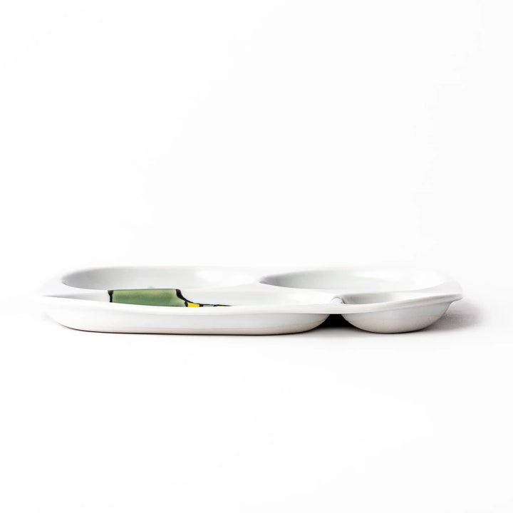 White ceramic kids divided plate with green T-Rex, purple pterodactyl, yellow grass and blue cloud accents