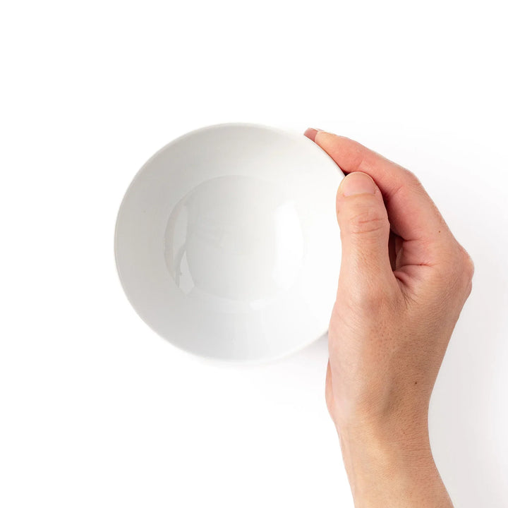 White ceramic kids rice bowl featuring green T-Rex dinosaur graphic with yellow accents and blue cloud motifs