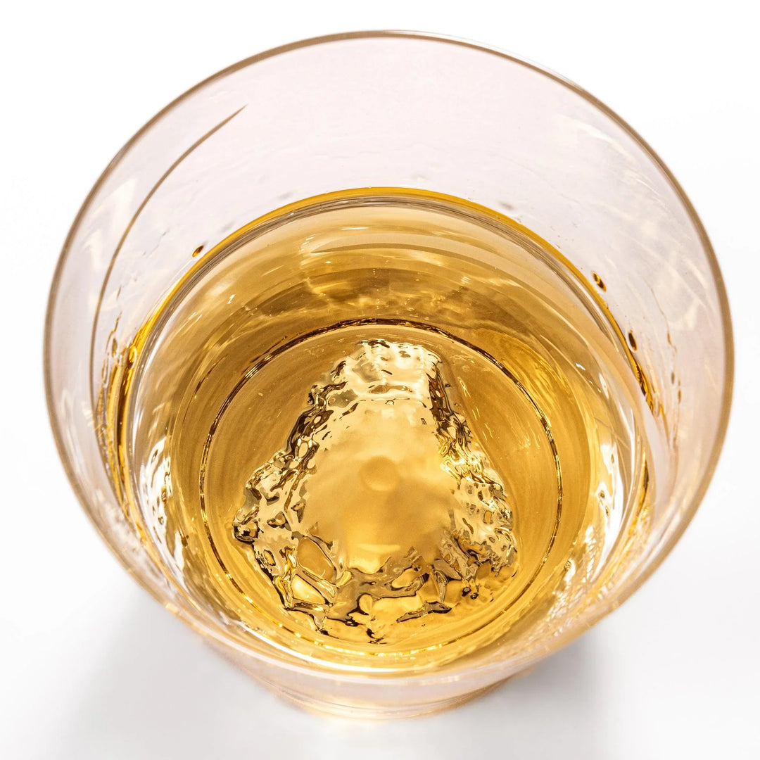 Clear glass tumbler with etched starburst motifs and diagonal swirl atop 3D Mount Fuji base for drinks.