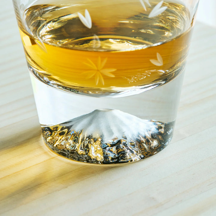Close-up of a Kiriko Japanese whiskey glass with Mt. Fuji design at the base and delicate floral cut patterns.