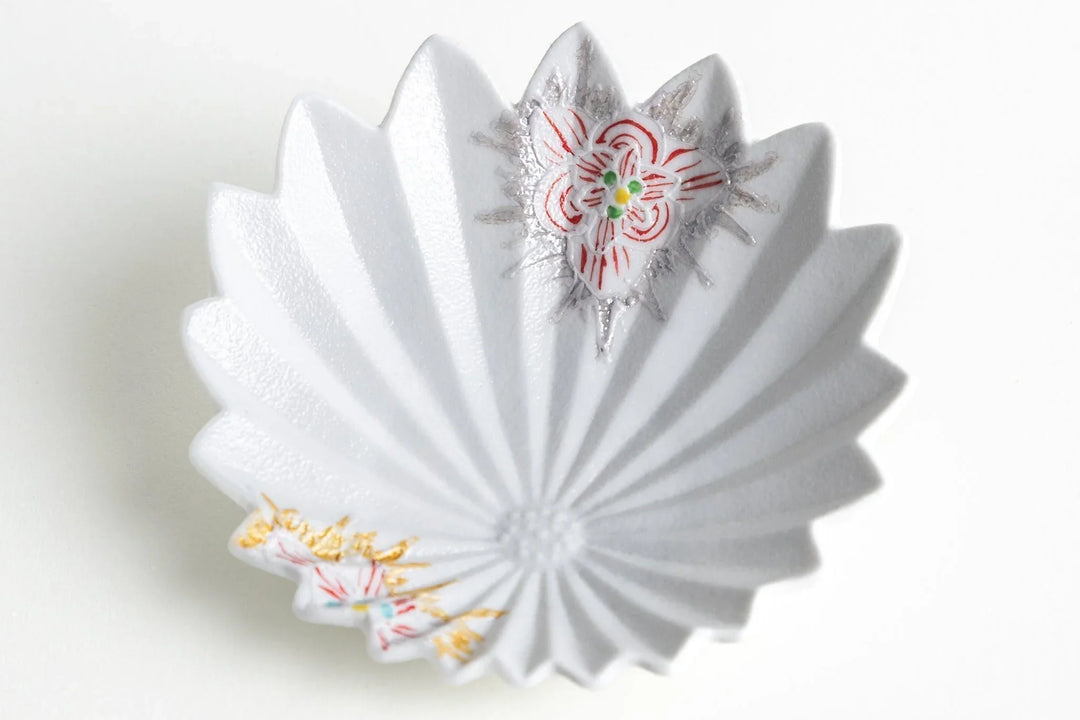 White fan-shaped porcelain dish with raised ridges and delicate red, gold, and silver floral accents on two edges.