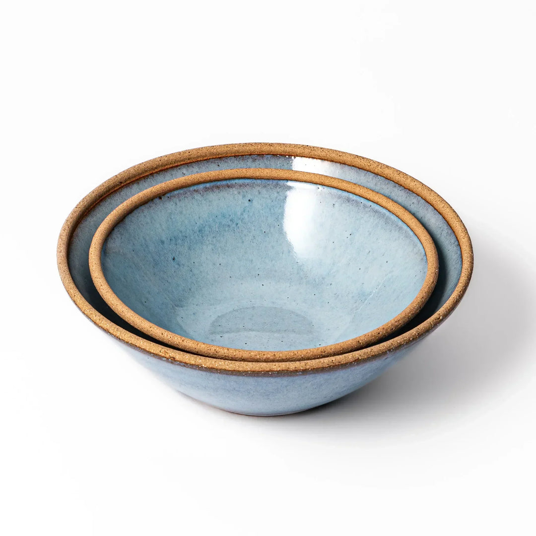Stackable terracotta blue ceramic bowls with rustic brown rims, handcrafted in Japan for daily meals and sides.