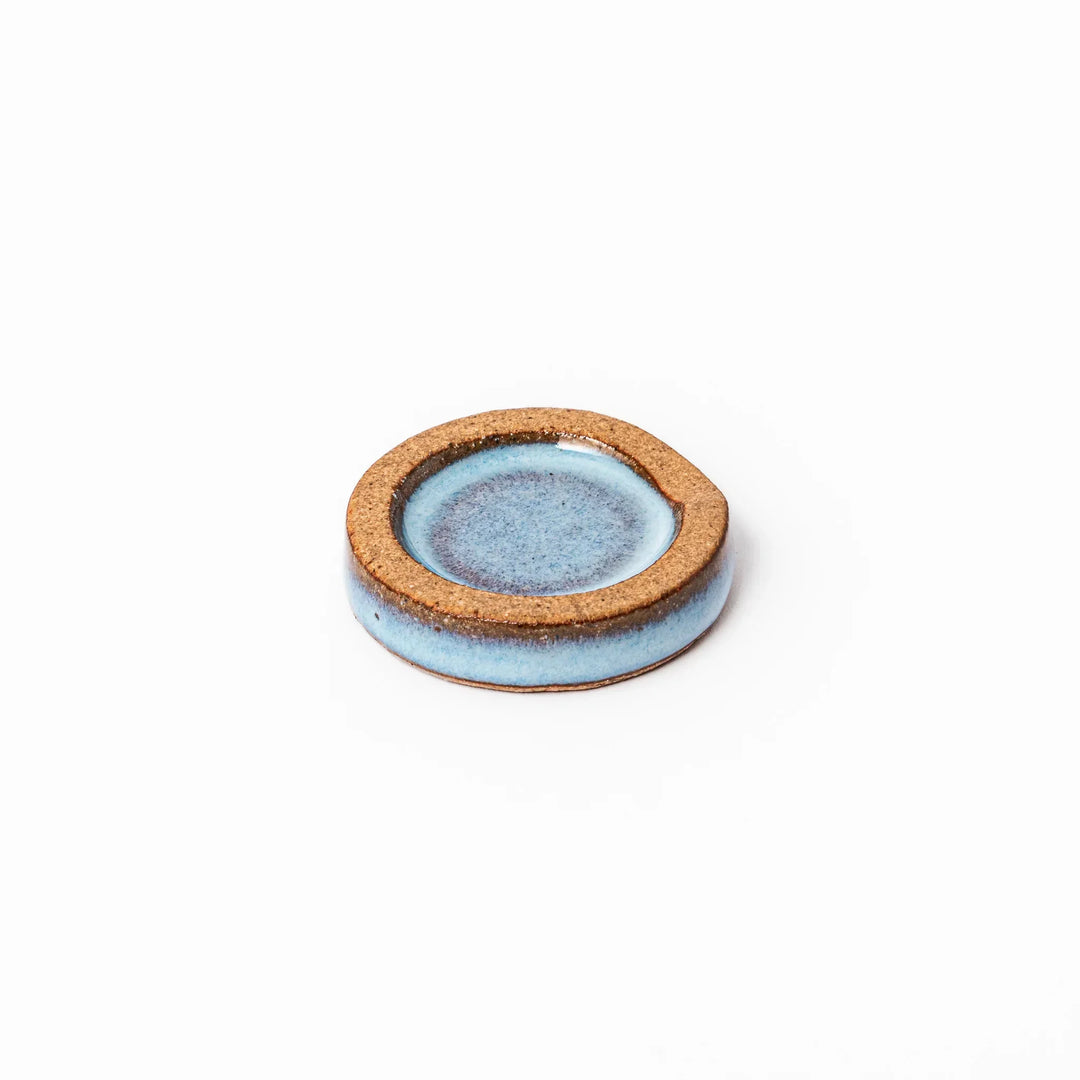Terracotta blue ceramic chopstick rest with rustic brown rim, handcrafted in Japan for an elegant dining accent.