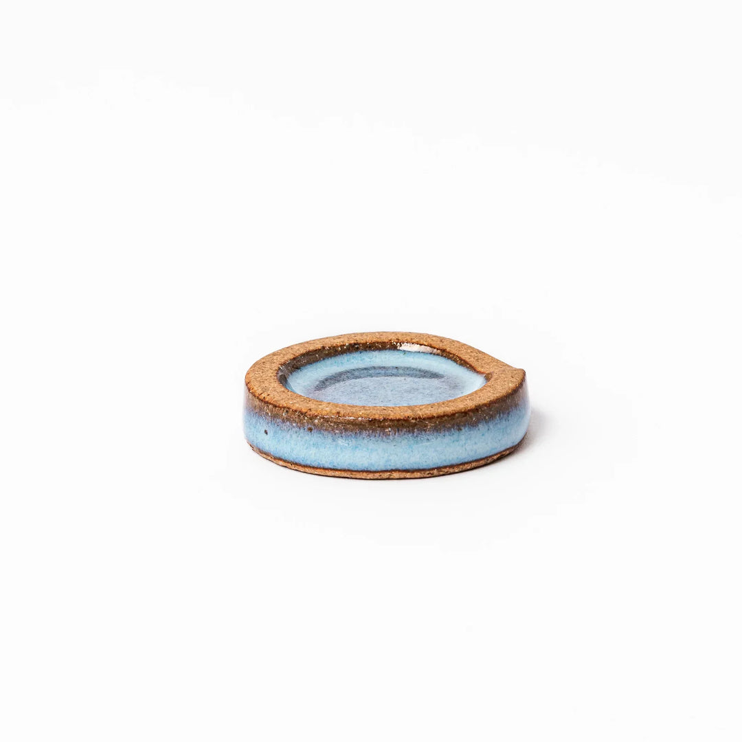 Terracotta blue ceramic chopstick rest with rustic brown rim, handcrafted in Japan for an elegant dining accent.