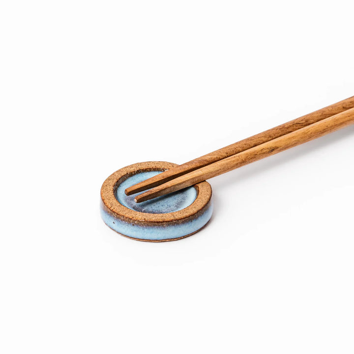 Terracotta blue ceramic chopstick rest with rustic brown rim, handcrafted in Japan for an elegant dining accent.
