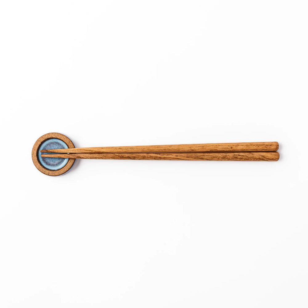 Terracotta blue ceramic chopstick rest with rustic brown rim, handcrafted in Japan for an elegant dining accent.