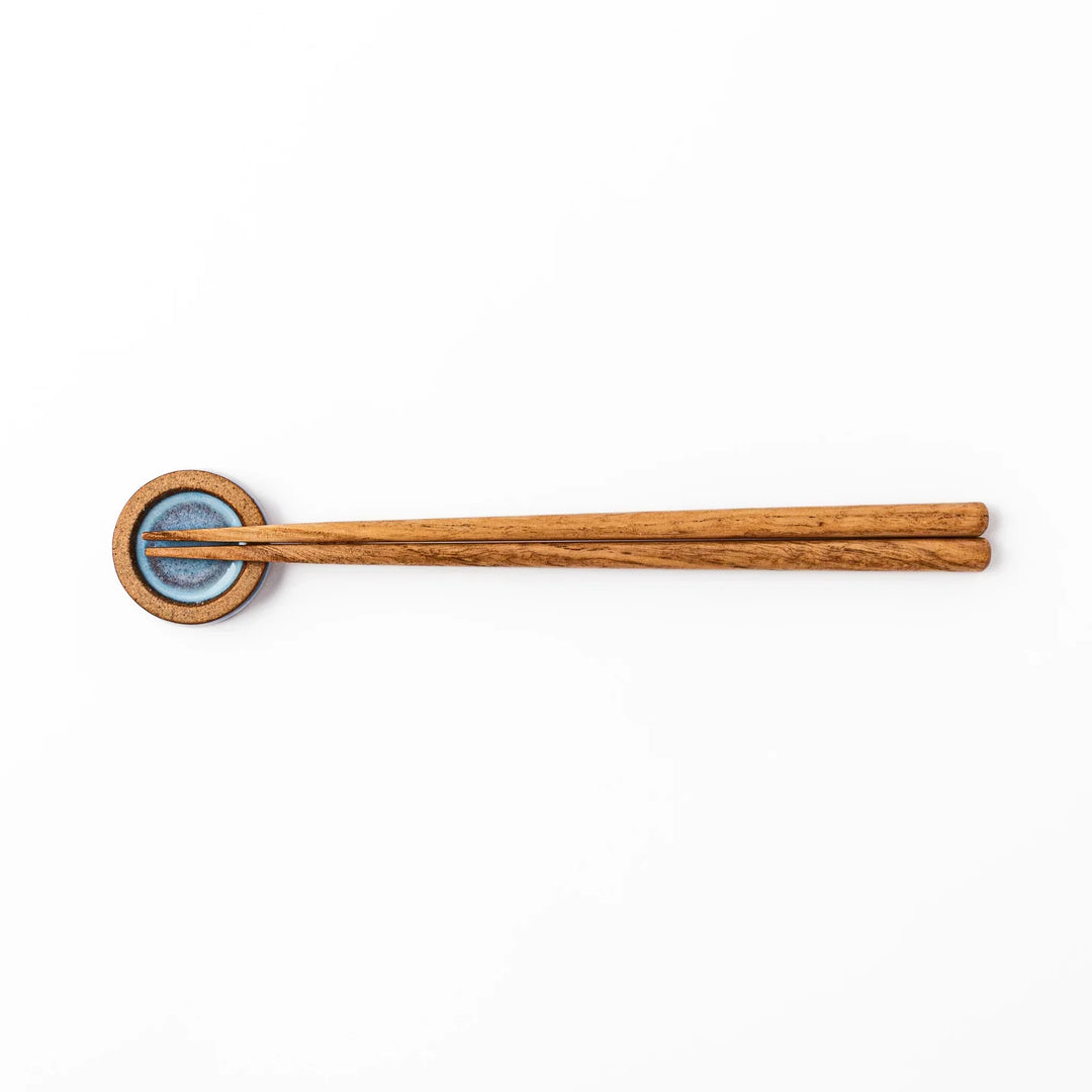 Terracotta blue ceramic chopstick rest with rustic brown rim, handcrafted in Japan for an elegant dining accent.