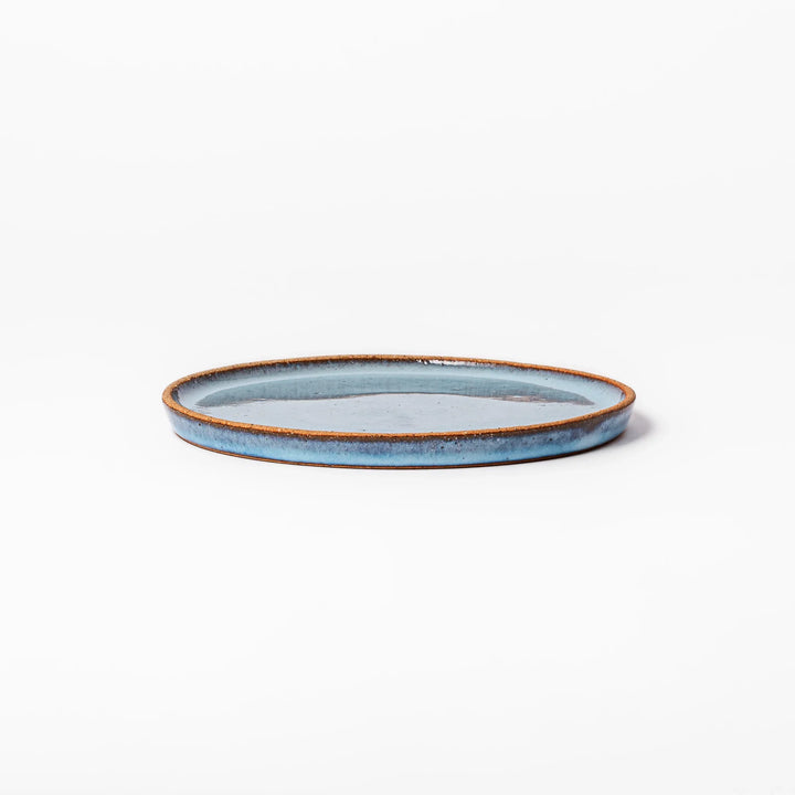 Terracotta blue ceramic dessert plate with rustic brown rim, handcrafted in Japan for serving cake, pastry, or appetizers.