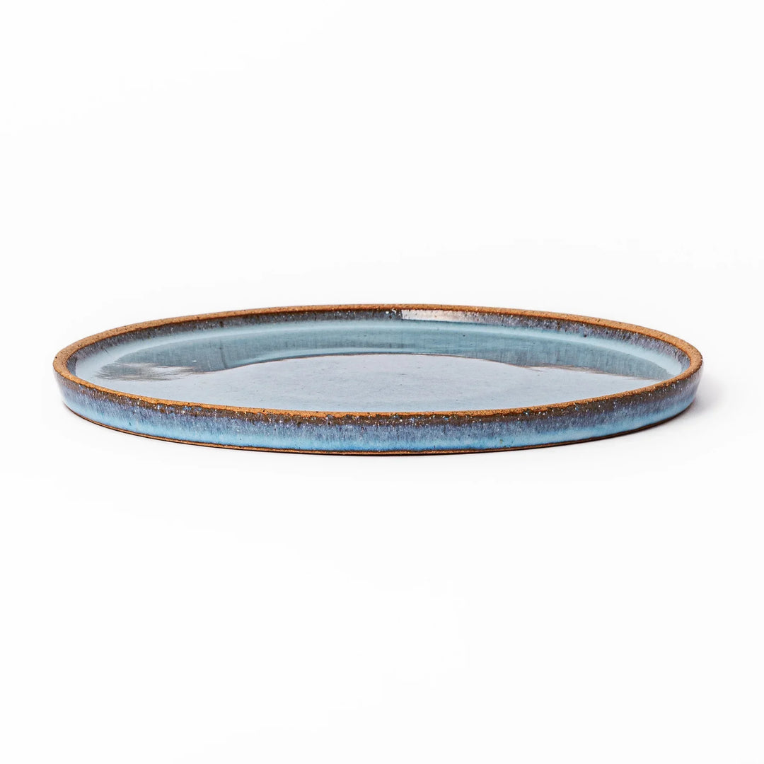 Terracotta blue ceramic dinner plate with rustic brown rim, handcrafted in Japan for daily meals or pasta dishes.
