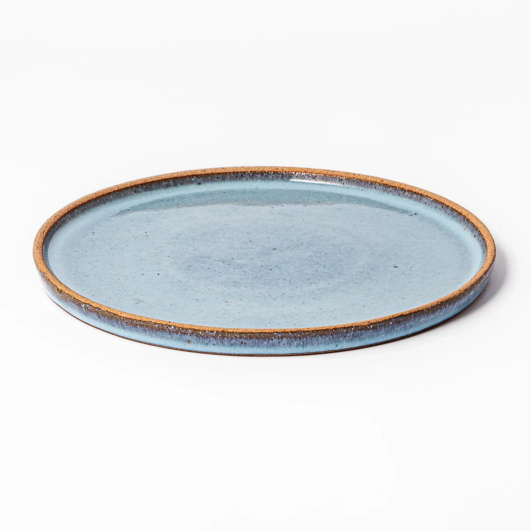Terracotta blue ceramic dinner plate with rustic brown rim, handcrafted in Japan for daily meals or pasta dishes.